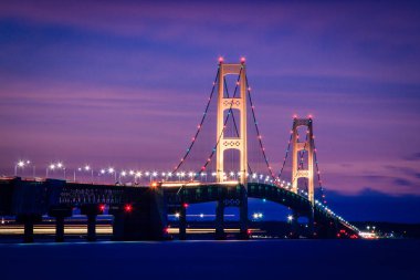 Alacakaranlıkta parlayan Mackinac Köprüsü. Michigan, ABD.