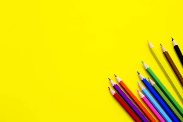 Sarı arkaplanda renkli kalemler.