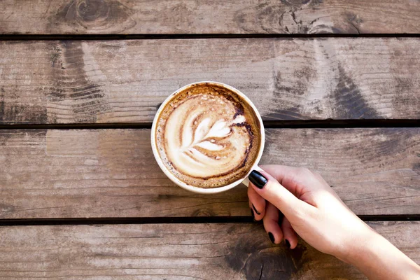 Person Hält Einen Kaffeebecher Auf Einem Holztisch Über Sich — Stockfoto