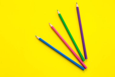 Sarı arkaplanda renkli kalemler.