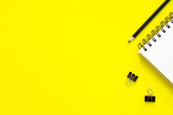 黄色の背景に鉛筆とノート — ストック写真