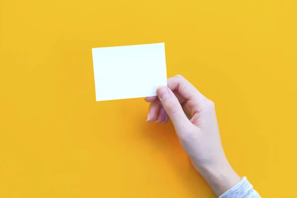 オレンジ色の背景に紙を持つ女性の手 — ストック写真