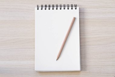 defter ve kalem ahşap masaya