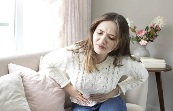 Güzel genç kadın evde karın ağrısı acı