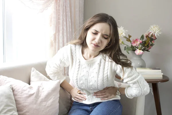 Güzel genç kadın evde karın ağrısı acı
