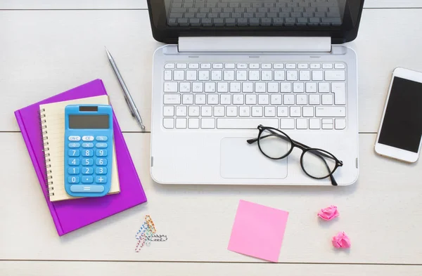 Beyaz ofis resepsiyon masası dizüstü bilgisayar, smartphone, defter, hesap makinesi ve gözlük. Üstten görünüm kopya alanı, düz ile yatıyordu.