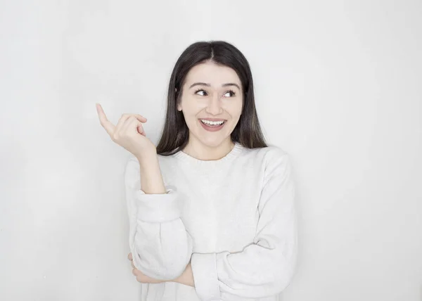 Genç güzel kadın üzerinden hayran ve el ile sunulması ve parmak ile işaret ederken gülümseyen izole arka plan.