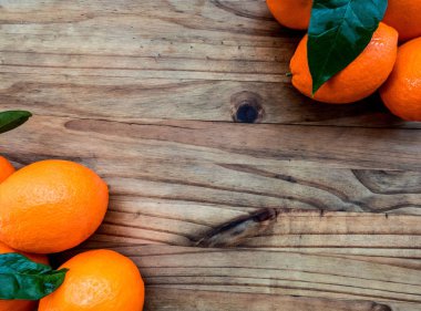 Portakal ile ahşap bir masa yapraklarda. Kopya alanı ile üstten görünüm.