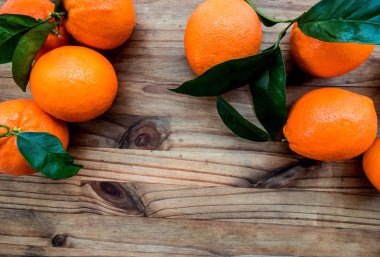 Portakal ile ahşap bir masa yapraklarda. Kopya alanı ile üstten görünüm.