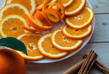 Orange plaka üzerinde sarmal lezzet ve tarçın tahta masada ile dilimlenmiş.