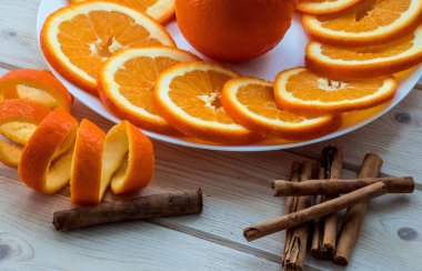 Orange plaka üzerinde sarmal lezzet ve tarçın tahta masada ile dilimlenmiş.