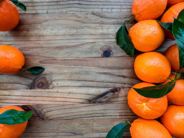 Portakal ile ahşap bir masa yapraklarda. Kopya alanı ile üstten görünüm.