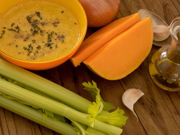 Maydanoz koyu ahşap masa selery, garlick ve kabak ang badem fındık parçaları üzerinde kabak ve havuç çorbası
