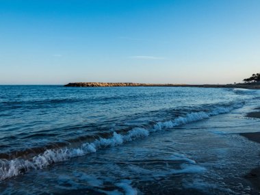 Gün batımında sahilde dalgalar ile deniz manzarası  