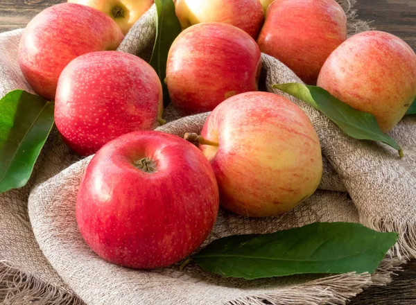 Red and pink apples with  green leaves on canvas, close up — Stock Photo, Image