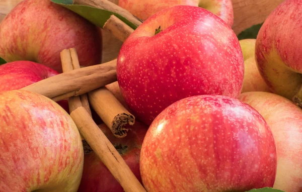 Äpfel von roter und rosa Farbe mit Zimtstangen aus nächster Nähe, hin und her — Stockfoto