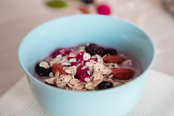 Healthy morning breakfast granola bowl with almond, raspberry, blueberry, blackberry