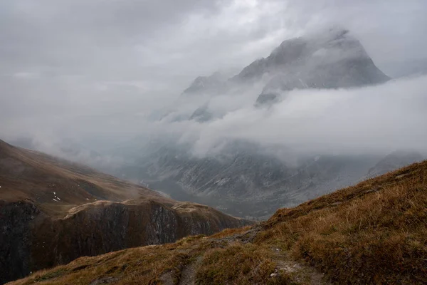 Dağ kısmen sarı gras ön planda, Tur de Mont Blanc ile bulutlar sardı