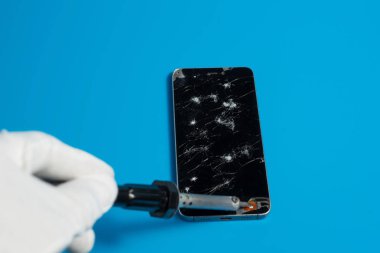 Akıllı telefonlar ile mavi bir arka plan üzerinde kırık ekran tamir