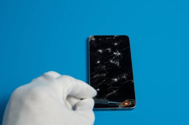 Akıllı telefonlar ile mavi bir arka plan üzerinde kırık ekran tamir