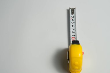 Santimetre, beyaz zemin üzerine sarı şerit metre.