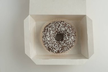 Bir kutu içinde beyaz arka plan üzerinde izole buzlanma ile çikolatalı çörek