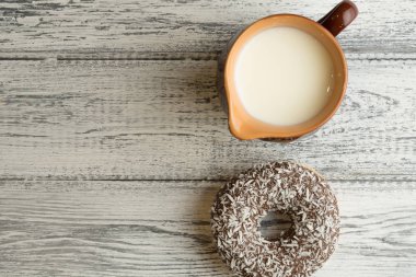 Çörek süt kabı ile beyaz ahşap arka plan üzerine krema ile