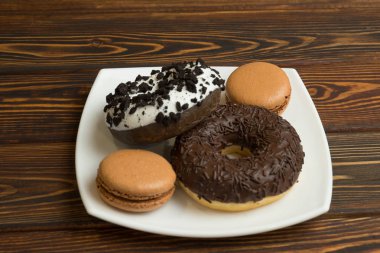 Çikolatalı donuts bir plaka üzerinde buzlanma ve macaron yalanla