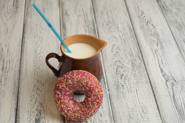 Çörek süt kabı ile beyaz ahşap arka plan üzerine krema ile