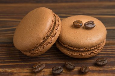 Çikolata macaroons kahve fasulye, koyu ahşap masa ile. Tatlı macarons. Üstten görünüm