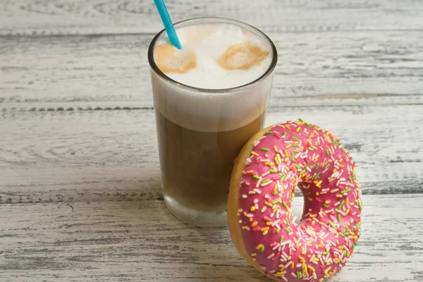 Çörek buzlanma ve kapuçino Beyaz ahşap zemin üzerinde