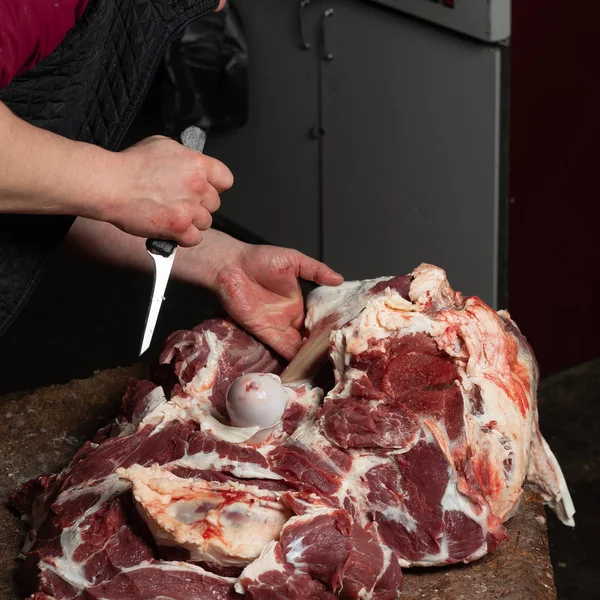 A butcher chopping beef for sale on the market