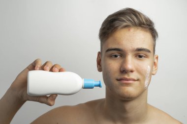 bir genç bir ilaç sivilce ve siyah nokta yüzünde kullanır.