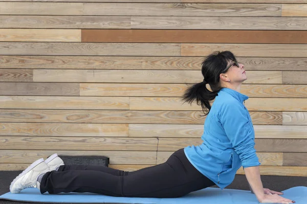 A mature woman is doing outdoor exercise