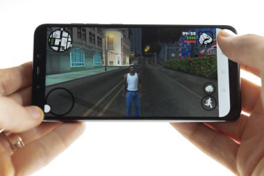 Sochi, Rusya Federasyonu-Ocak 27, 2018: Bir adam Smartphone cep telefonu ile Gta oyun oynuyor