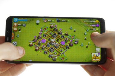 Sochi, Rusya Federasyonu-Ocak 27, 2018: Bir adam çatışmada Smartphone cep telefonu ile Pocophone Xiaomi tarafından klan oyun oynuyor