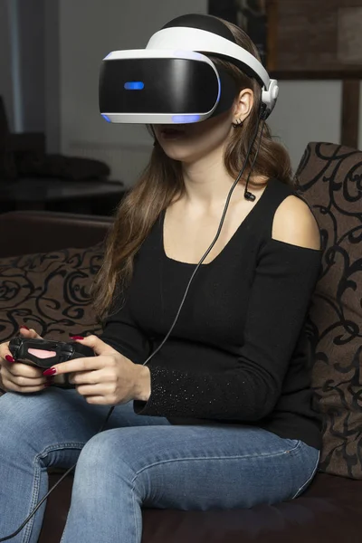 A Girl is watching a video in 360 degrees virtual reality helmet. VR equipment headset.