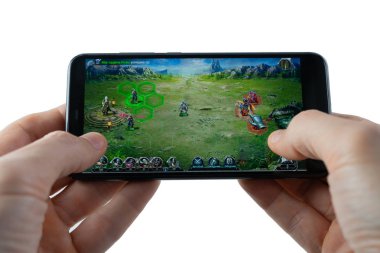 Sochi, Rusya Federasyonu-Şubat 24, 2019: Bir adam smartphone cep telefonu ile savaş ve Magic oyun oynuyor