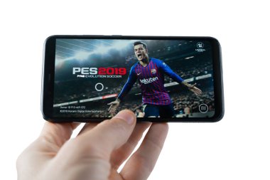 Sochi, Rusya Federasyonu-Şubat 24, 2019: Bir adam Pes 2019 pro evolution soccer oyunu smartphone cep telefonu ile oynuyor