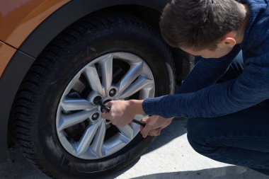 Adam açık havada bir araba tekerlek tamiri