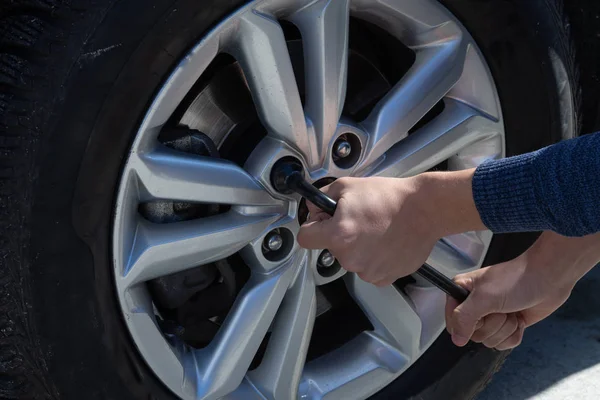 Bilden av mannen som unscrews hjulet skiftnyckeln — Stockfoto