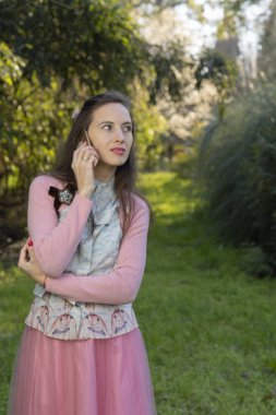 Güzel retro vintage kız parkta telefonda sohbet. Kavramlar açık, açık hava