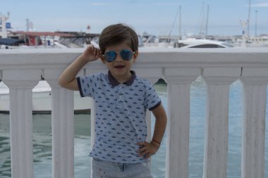 Marinada tatil inanangüneş gözlüğü takan şık bir çocuğun portresi