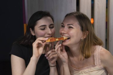 Kız arkadaşlar pizzacıda pizza yerken eğlenirler. Öğle yemeği ve pizza zamanı