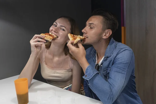 Pärchen essen in der Pizzeria Pizza. Junge und Mädchen teilen sich eine Mahlzeit im Café — Stockfoto