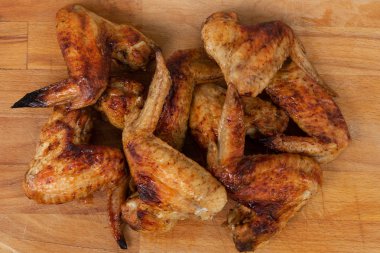 Ahşap masada servis edilen fırında tavuk kanatları