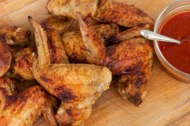 Ahşap masada sriracha soslu tavuk kanatları