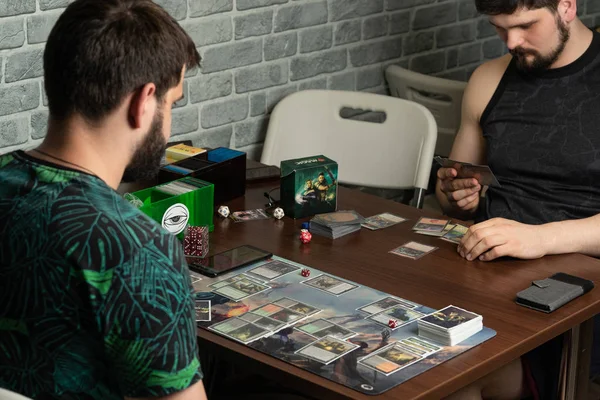  İki sakallı hipsters masa oyunu The War of the Spark Magic The Gathering yatıyor yeni bir parçası oynuyor