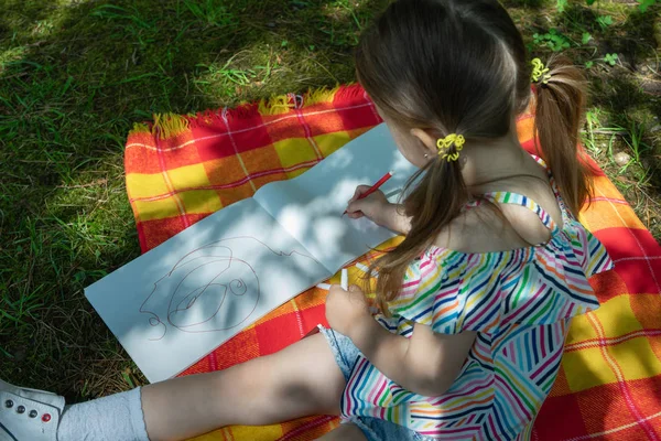 Dziecko dziewczynka jest rysunek z filcu końcówki pióra w parku — Zdjęcie stockowe
