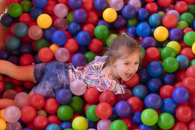 Kız bebek renkli topları ile oyun oynuyor